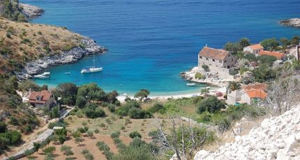 Rustige baai in Kroatië met helder turquoise water, omgeven door groene heuvels