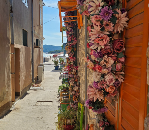 Smal stenen straatje met kleurrijke bloemen in Kroatië