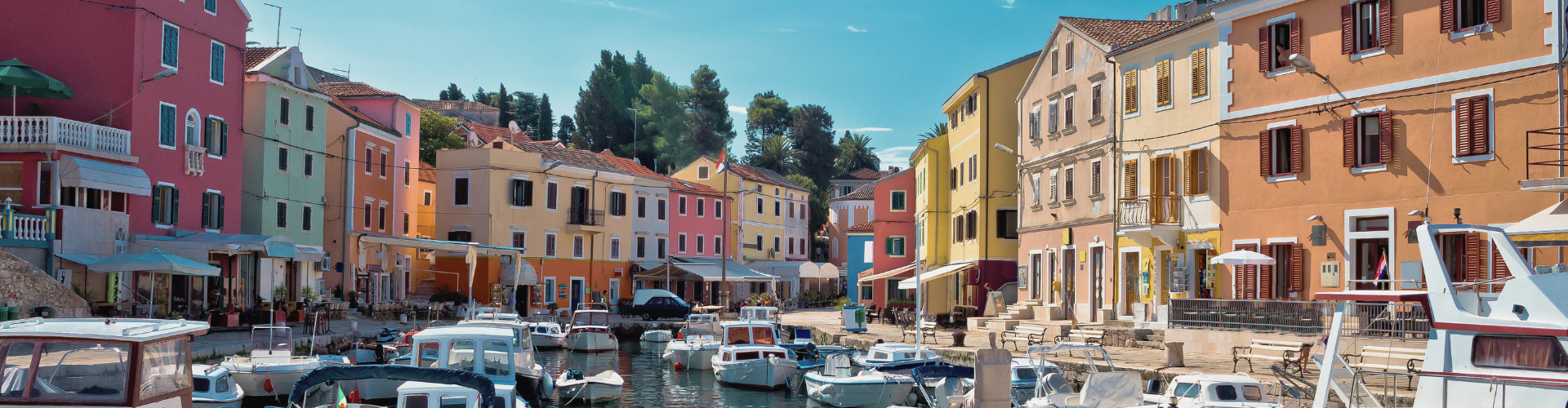Kleurrijke historische huizen en bootjes in een sfeervolle haven in Kroatië