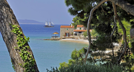 Uitzicht tussen het groen op een baai en de Adriatische Zee in Kroatië