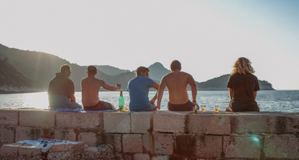 Mensen genieten van de zonsondergang aan het water in Biograd na Moru