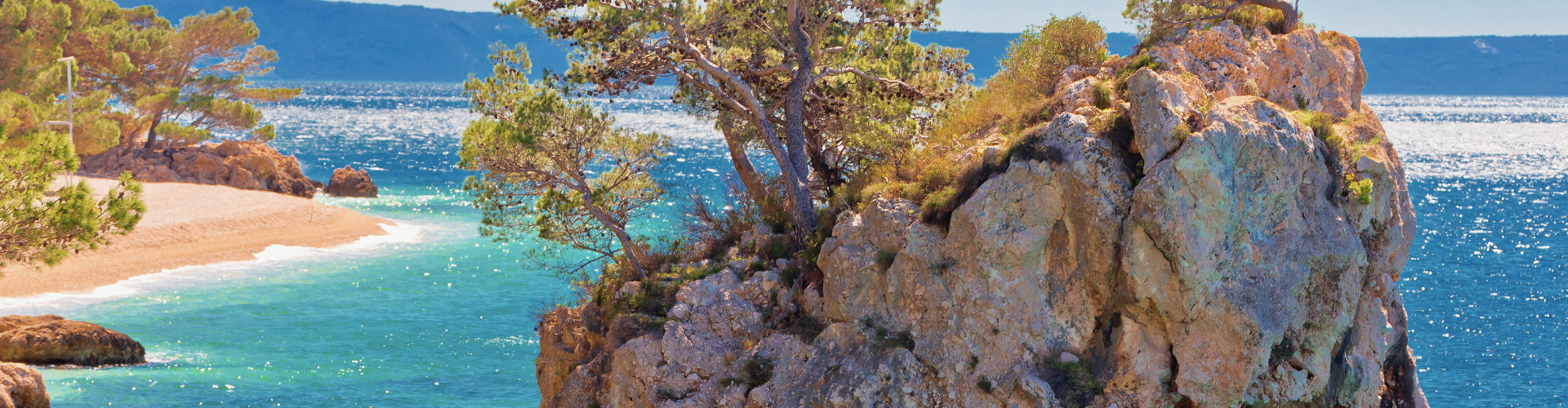 Rotsachtige Kroatische kust met pijnbomen en helder turquoise zeewater