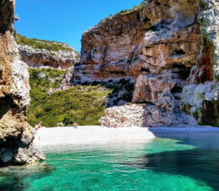 Verscholen baai met turquoise water en rotsen in Dalmatië