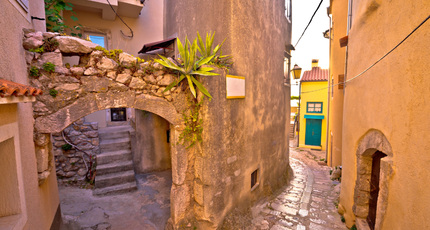 Smal historisch straatje met natuurstenen huizen in Kroatië - 55+ slow travel Kroatië