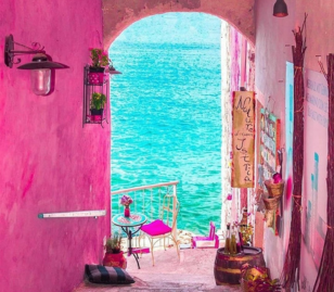 Kleurrijk straatje in Rovinj dat uitkomt op de helderblauwe zee in Kroatië